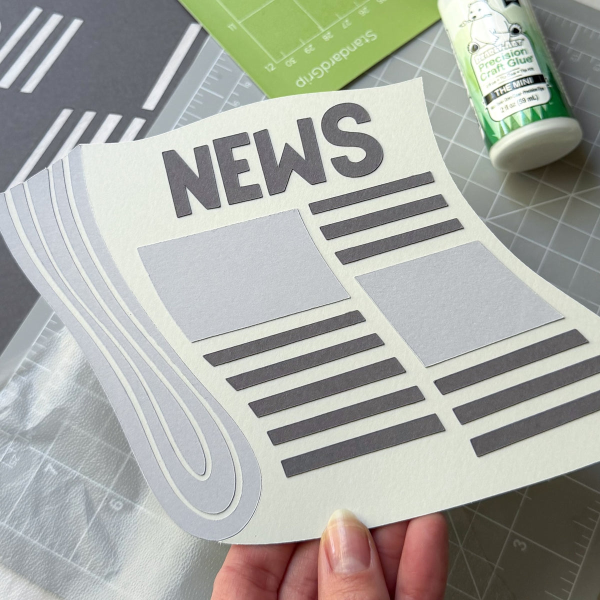 Die cut paper newspaper using Lessebo Pashmina, Rhino, and Dove Gray