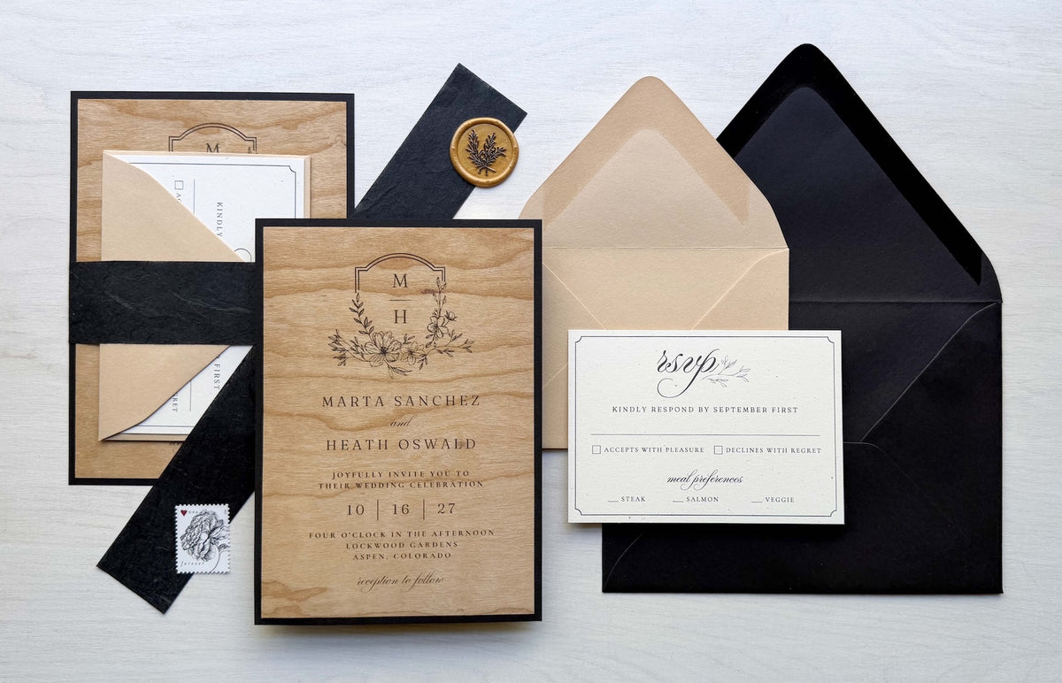 wedding invitation uite with Wood Veneer and Madero Beach printed cards, Sirio Ultra Black and Stone envelopes, and a Black Thai belly band